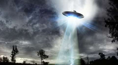 A flying saucer beaming light down from storm clouds, illustrating the theory that links the Nephilim to alien deception